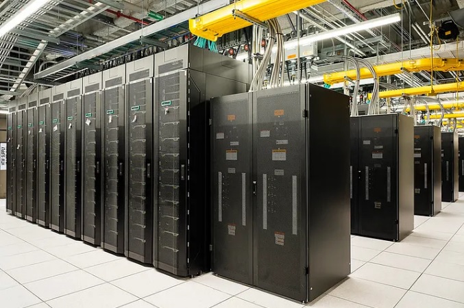 Data hall aisle with rows of black server and power cabinets under overhead busway