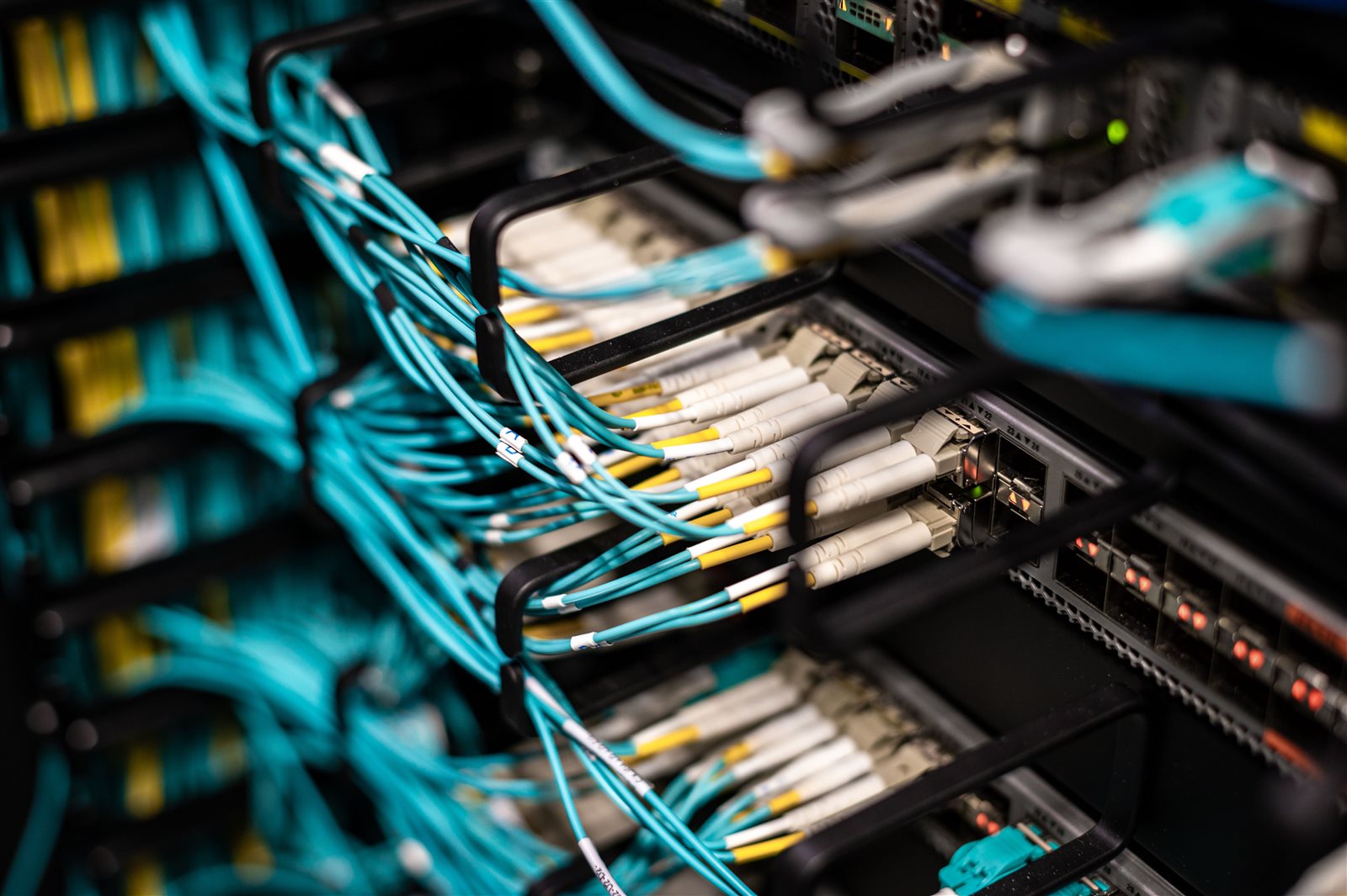 Close-up of aqua fiber patch cables connected to a Cisco Nexus switch in a server rack